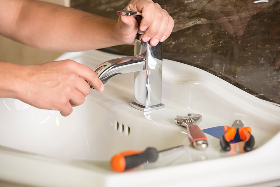 Sink faucet repair with tools on the counter