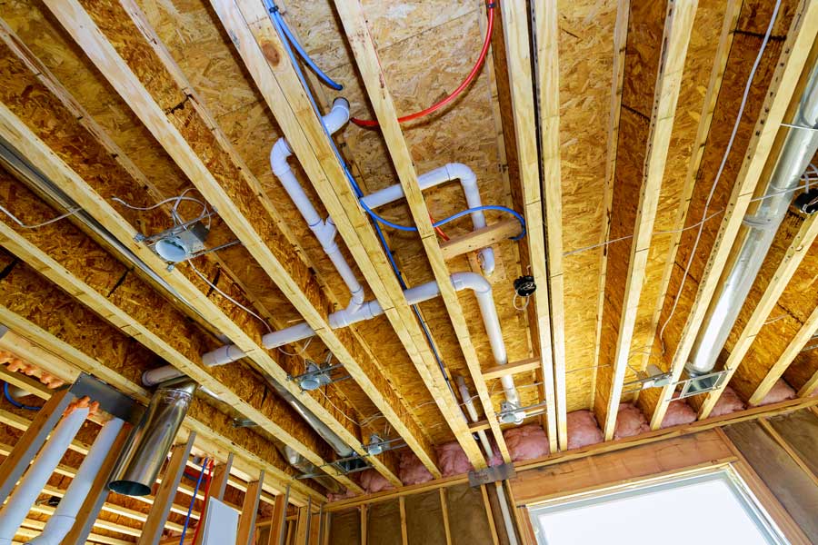Ceiling with exposed wooden joists, ventilation ducts, and utility lines