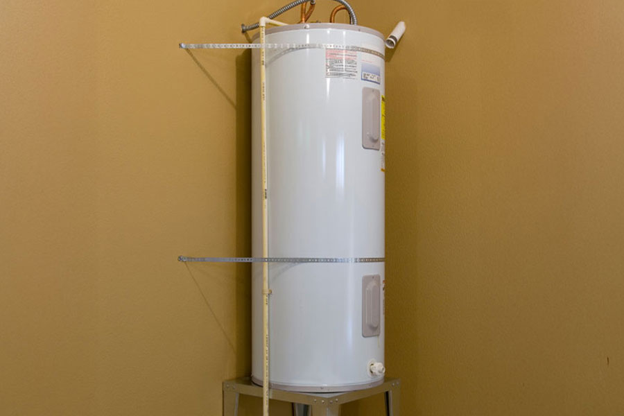 Water heater installed on a metal stand against a wall