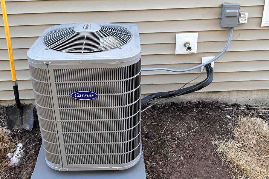 Carrier outdoor air conditioning unit installed beside a house